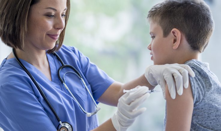 boy receiving vaccine from nurse