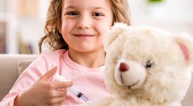 little girl giving teddy a vaccination