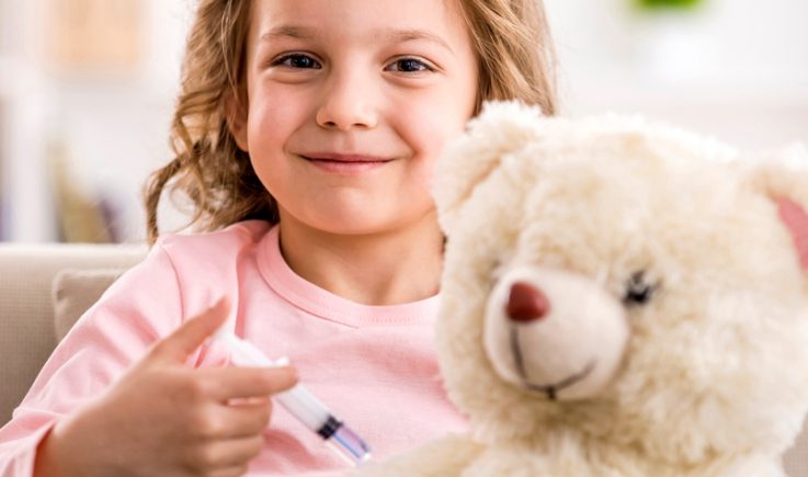 little girl giving teddy a vaccination