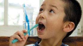 young boy brushing teeth