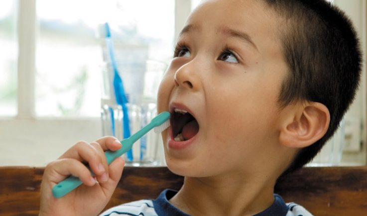 young boy brushing teeth