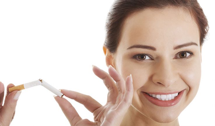 smiling woman breaking cigarette in half