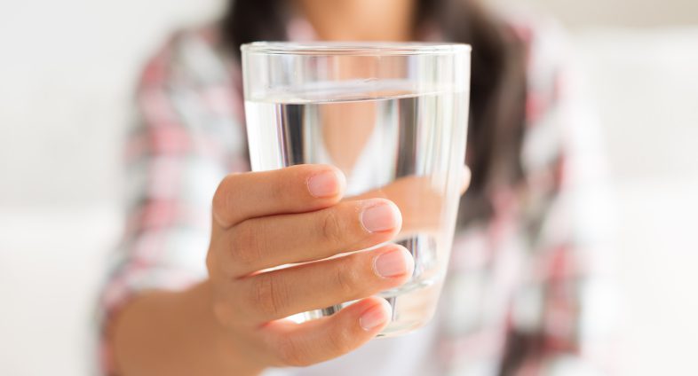 woman holding glass of water