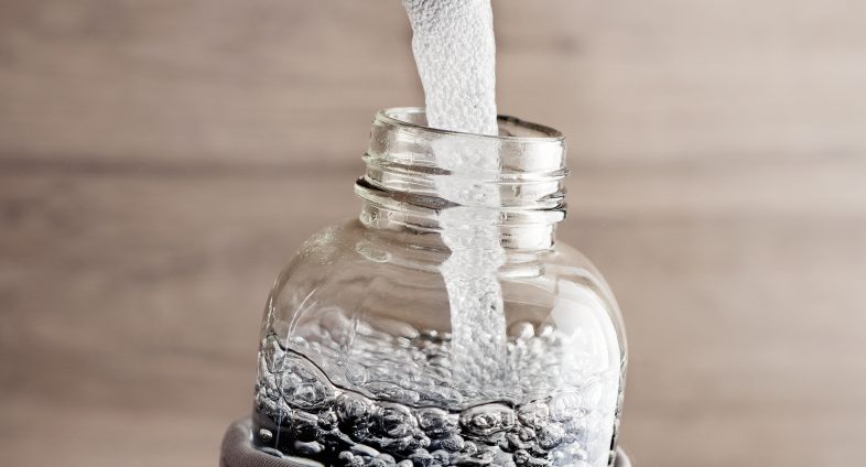 water pouring from tap into reusable bottle