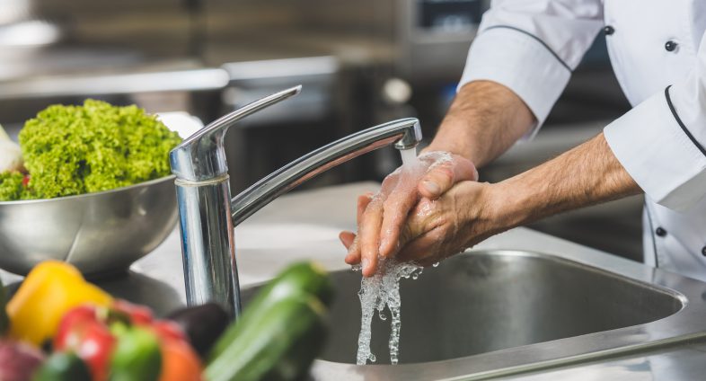 chef washing hands in sink