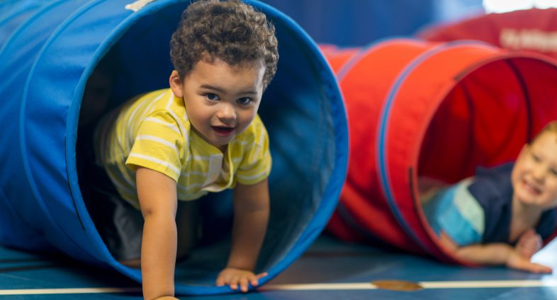 toddler boy playing in tubes