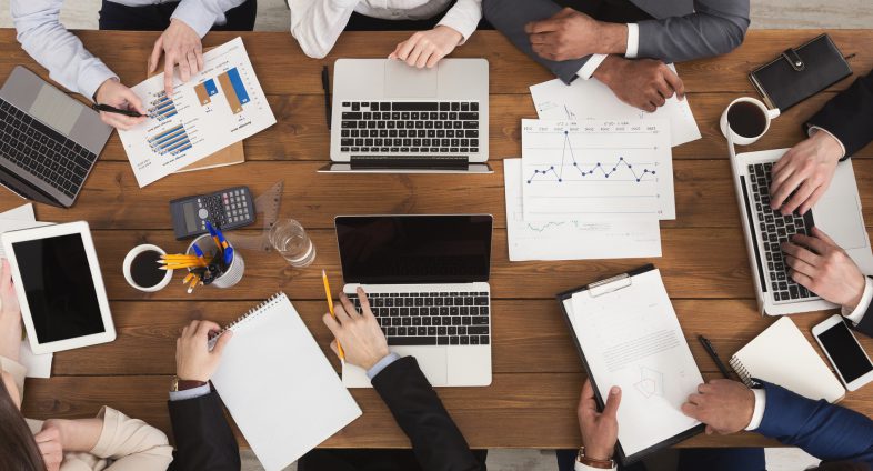 top view of business table with computers and charts