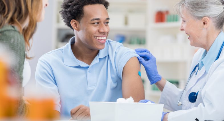 young man received vaccine from nurse