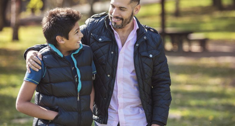 dad walking with arm around son's shoulder