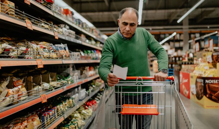 man pushing cart in grocery store